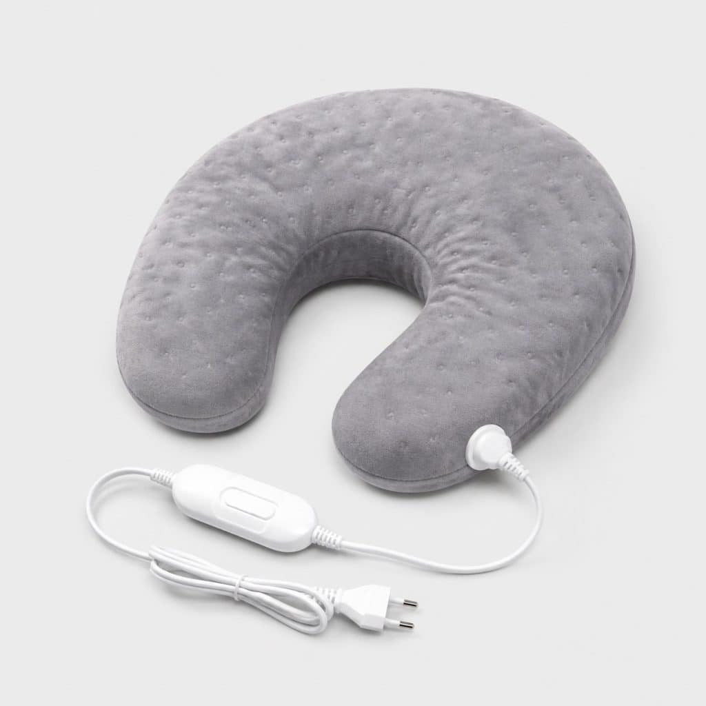 Coussin chauffant électrique posé seul sur fond neutre