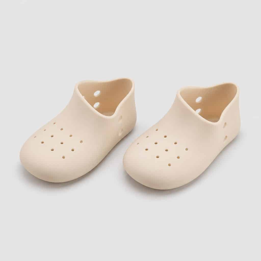 Deux protections en silicone souple beige clair posées seules sur fond neutre clair